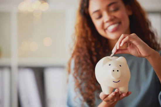 Women Counting Coins in a Piggy Bank